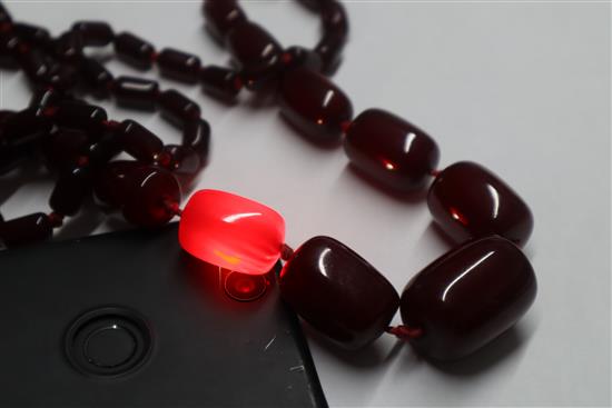 A single strand graduated simulated dark cherry amber necklace, gross weight, 98 grams,